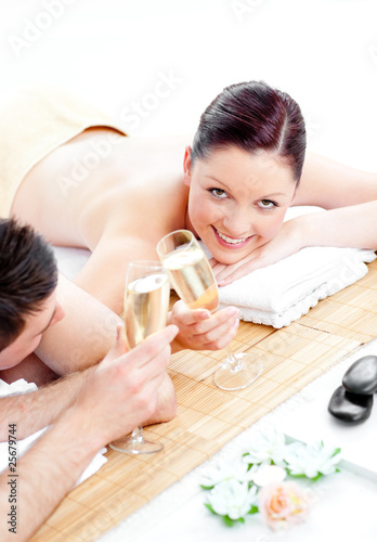Caucasian young couple lying on a massage table and drinking cha
