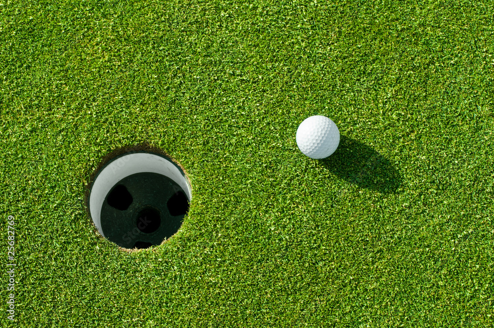 Obraz premium Golfball vor Loch
