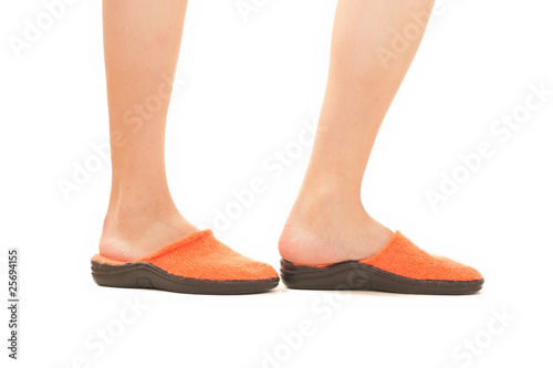 woman stay in bright orange slippers on white background
