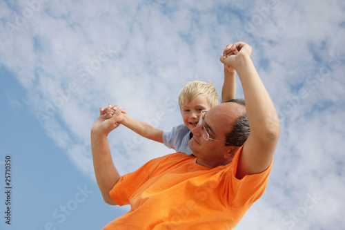happy father and son on sky background