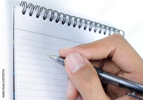 man hand is writing on a book