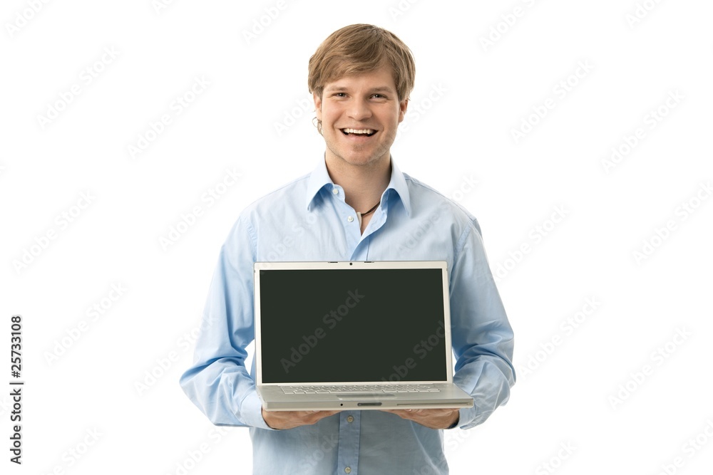 Young man holding laptop with blank screen