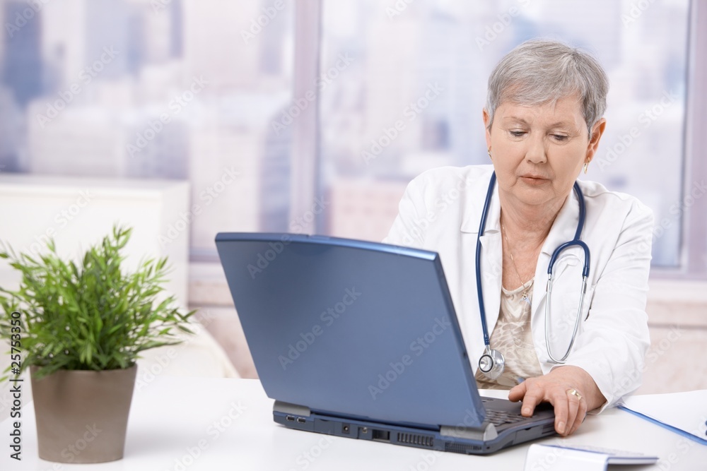 Senior doctor looking at screen Senior doctor looking at screen