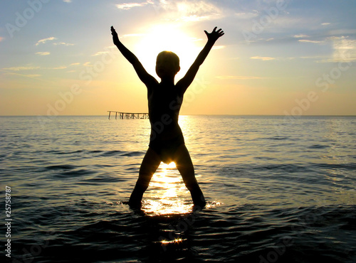 happy boy silhouette in the sea photo