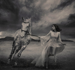 Fine art photo of a young beauty running with a horse