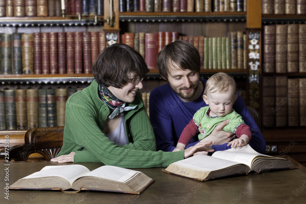 Happy family with a child reading in classic library Happy family with a child reading in classic library