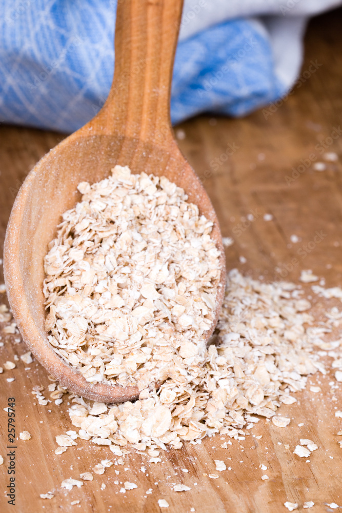 oat flakes in wooden spoon oat flakes in wooden spoon