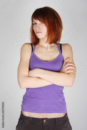 young redhead girl in purple shirt with crossed hands, dissatisf