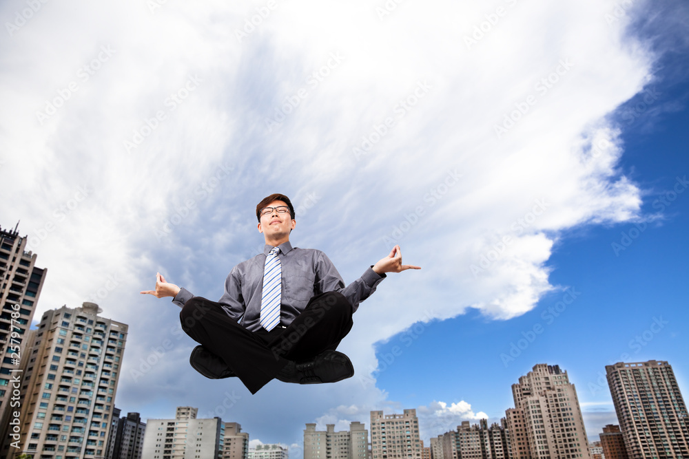 Businessman meditating in the air with yoga Businessman meditating in the air with yoga