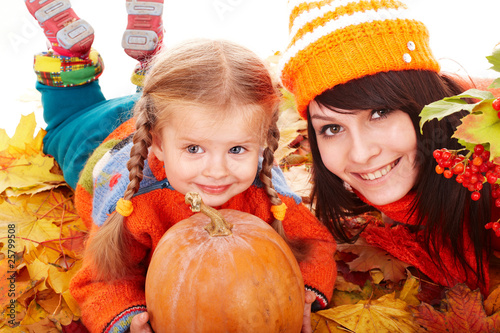 Happy family with  pumpkin on autumn leaves.