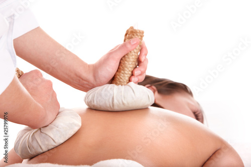 Girl  having Thai herb compress massage in beauty spa. photo