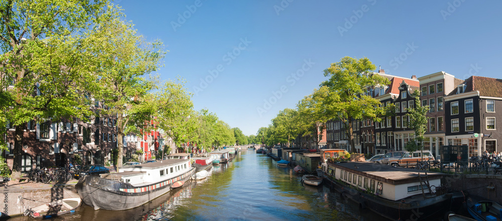 Obraz premium Small canal in Amsterdam with house boats.