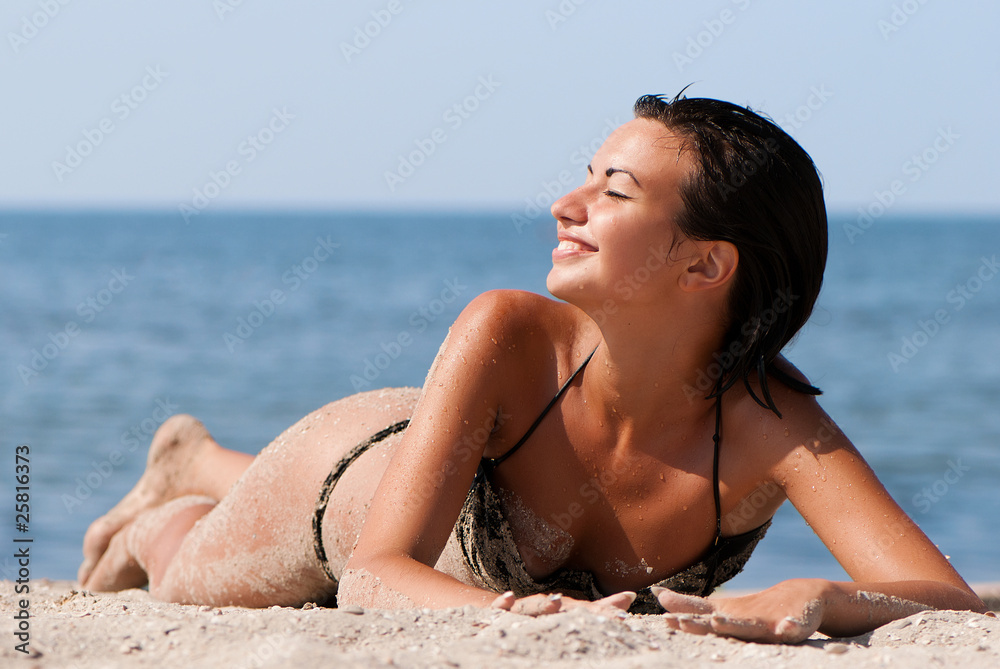 Young and sensual woman enjoying a sunny day on beach