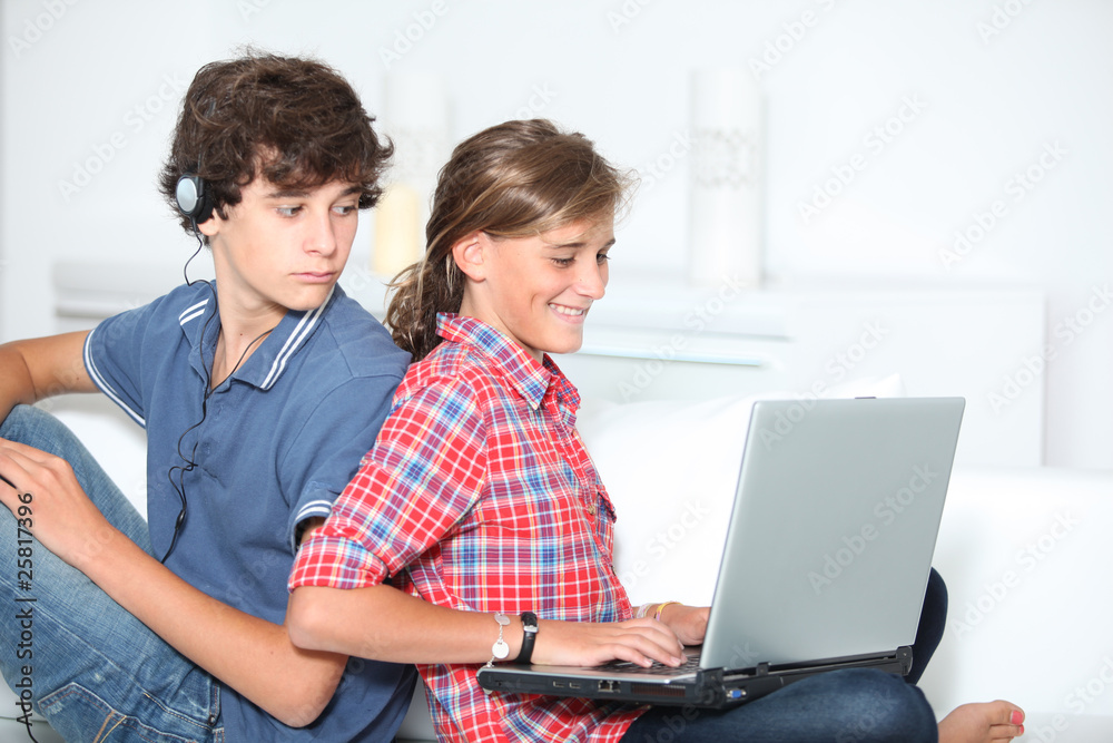 Teenagers with music player and computer at home