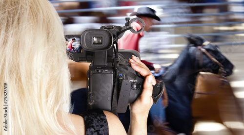 Blonde woman video recording horce race photo