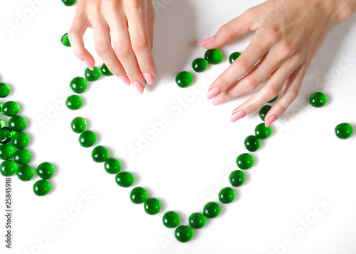 Beautiful hands building a heart sighn from green stones. isolat