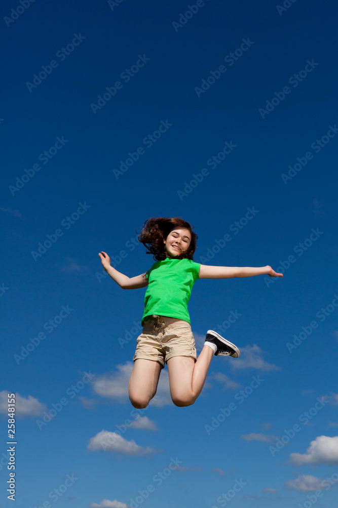 Girl jumping, running against blue sky