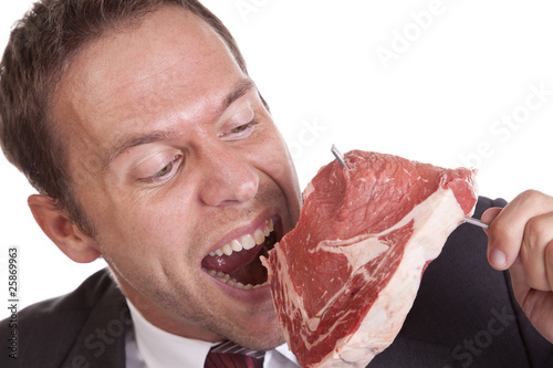 Man taking bite out of raw steak