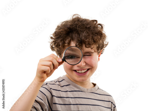 Boy looking through magnifying glass isolated on white