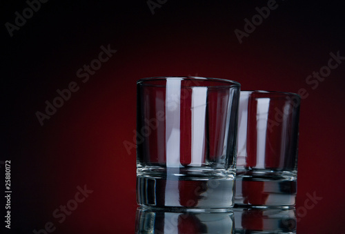 two empty glasses on a red bg