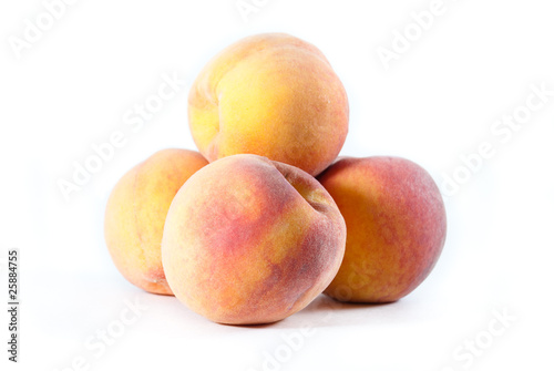 Pile of fresh peaches on a white isolated background
