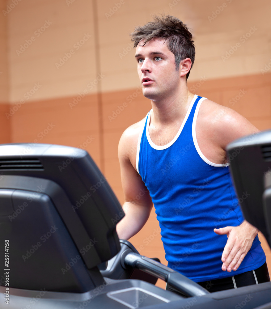Concentrated athletic man training on a running machine Concentrated athletic man training on a running machine