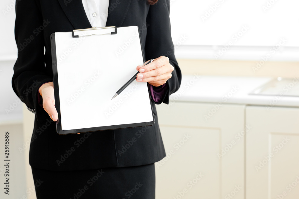 Close-up of a businesswoman holding a clipboard and a pen Close-up of a businesswoman holding a clipboard and a pen