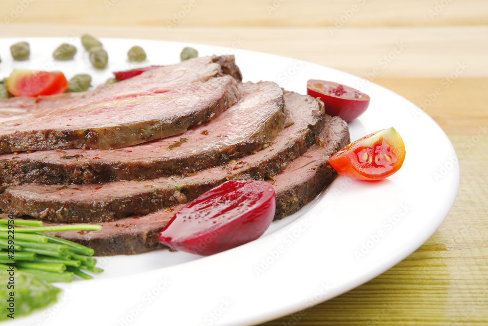 roasted meat served on white dish over wood roasted meat served on white dish over wood
