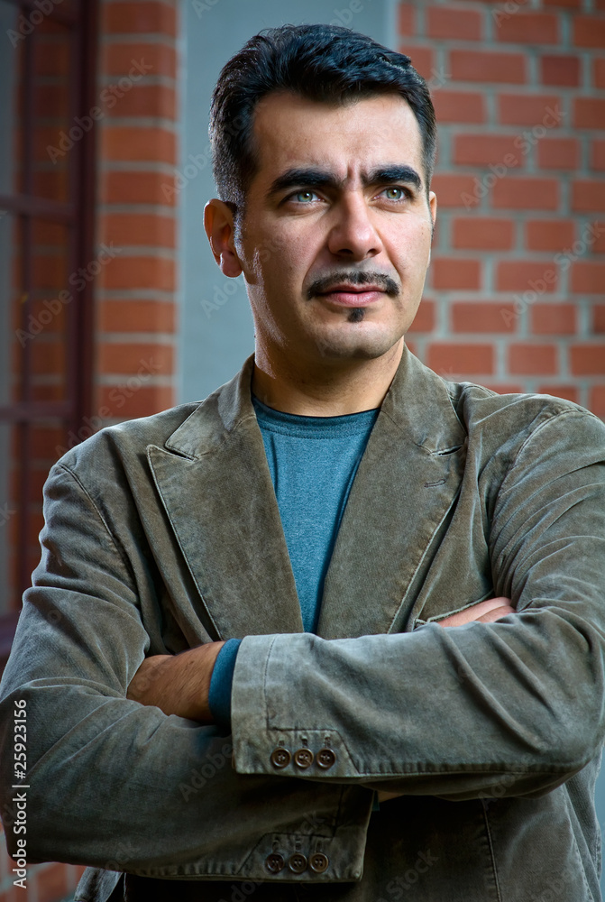 Fototapeta premium Portrait of a confident handsome man with arms crossed