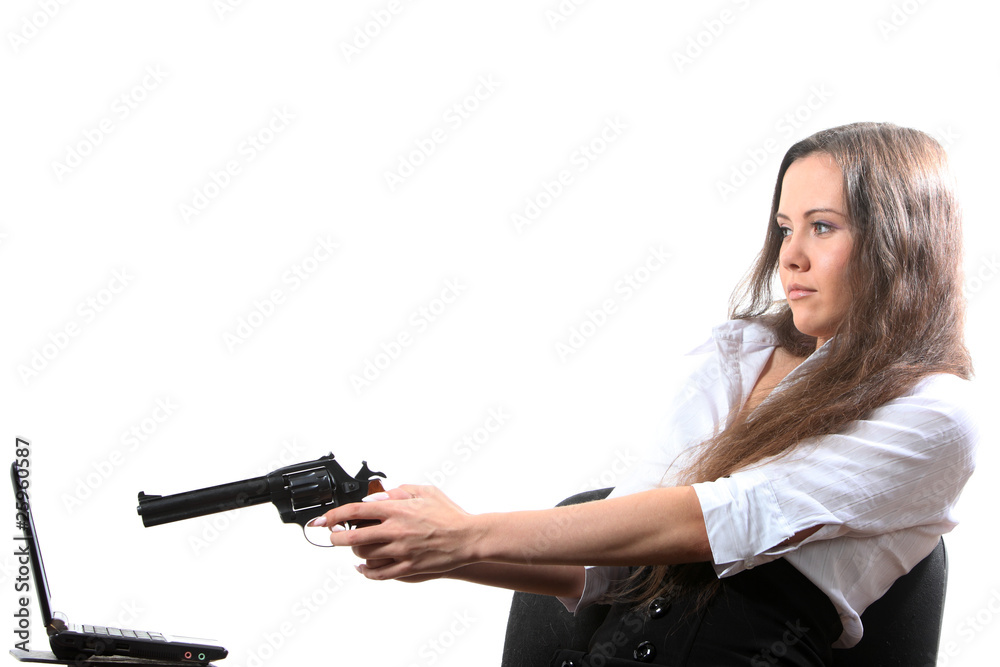 Businesswomen is aiming a revolver at a notebook Businesswomen is aiming a revolver at a notebook