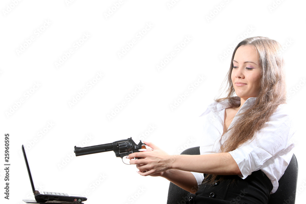 Businesswomen is aiming a revolver at a notebook Businesswomen is aiming a revolver at a notebook