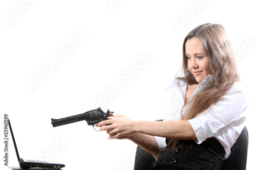 Businesswomen is aiming a revolver at a notebook