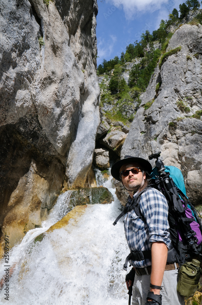 Fototapeta premium Wanderer bei Wasserfall in der Silberkar-Klamm am Dachstein