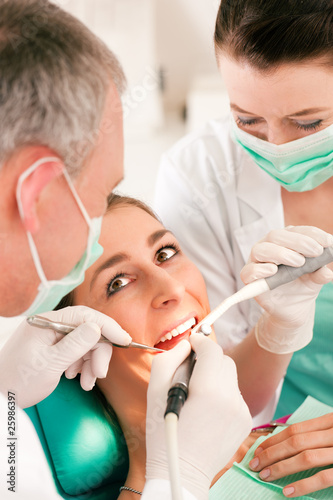 Patientin bei Zahnarzt - Behandlung mit Bohren photo