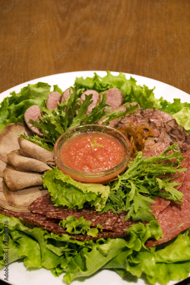 Appetizer made of meat delicacies and salad Appetizer made of meat delicacies and salad