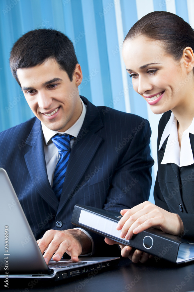 Two happy businesspeople working together at office Two happy businesspeople working together at office