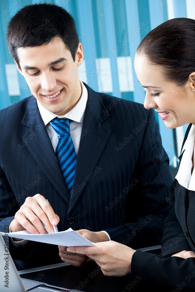 Two happy businesspeople working together at office Two happy businesspeople working together at office