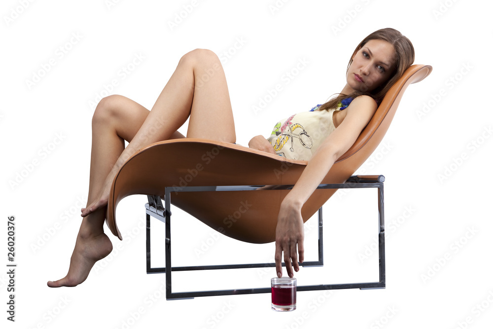 Obraz premium Female relaxing in the fashionable chair with glass of juice