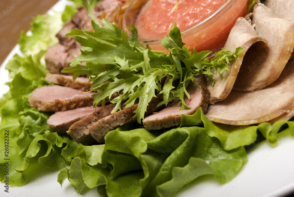 Appetizer made of meat delicacies and salad Appetizer made of meat delicacies and salad
