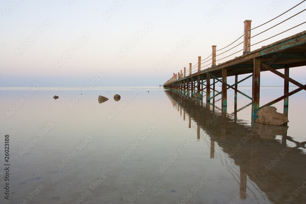 bridge stretching out into vast ocean