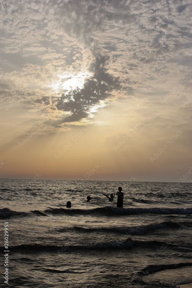 bambini che giocano in mare al tramonto