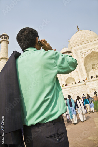 Indian businessman on cell phone visiting Taj Mahal photo