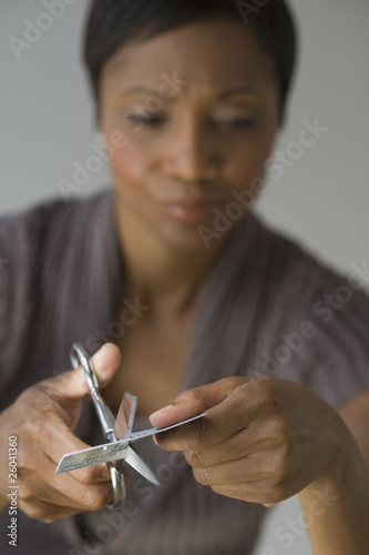 Frustrated African woman cutting up credit card photo