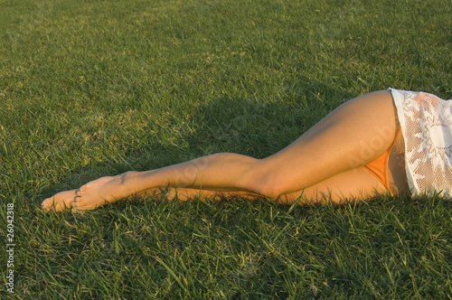 Woman with bare legs laying in grass