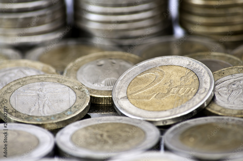 Grungy 2 euro coin with coins on background Grungy 2 euro coin with coins on background