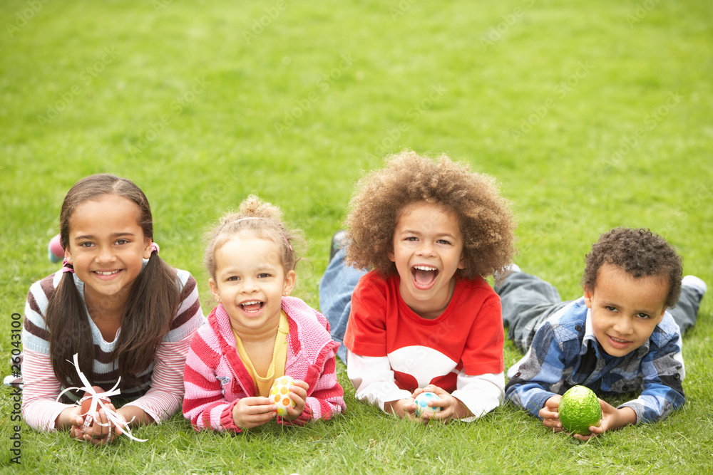 Group Of Children Laying On Grass With Easter Eggs Group Of Children Laying On Grass With Easter Eggs