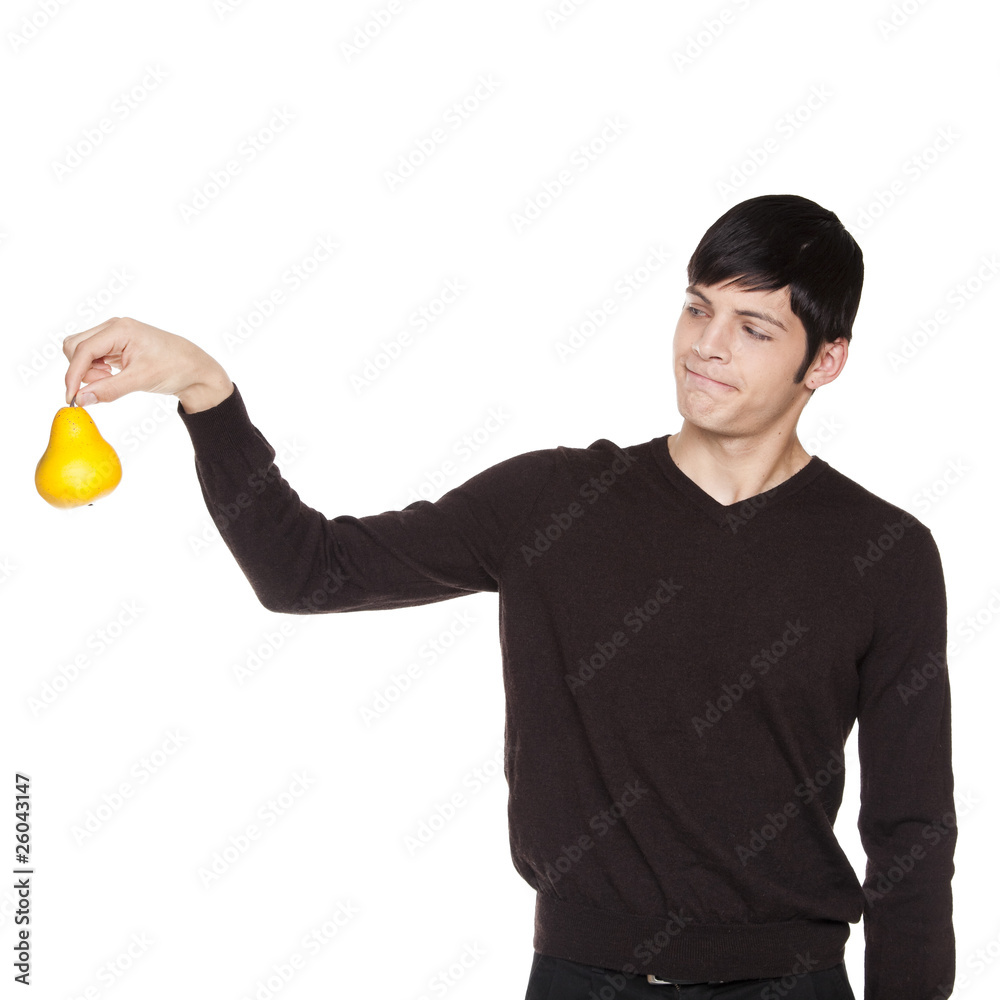 Caucasian man holding pear away with upset look Caucasian man holding pear away with upset look