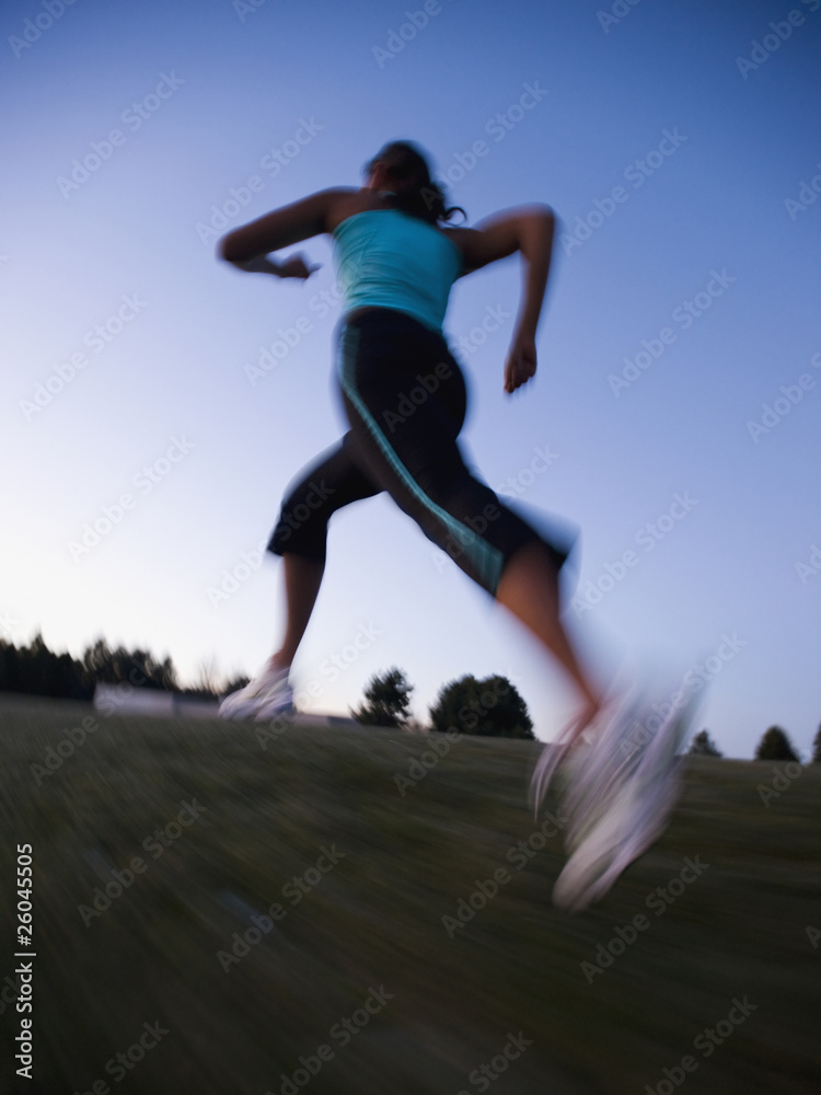 Mixed race woman running on grass Mixed race woman running on grass