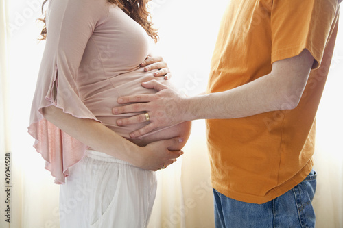 Hispanic man touching pregnant wifeÕs stomach