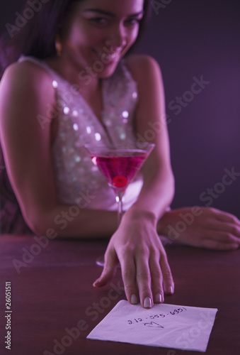 Hispanic woman offering telephone number on napkin